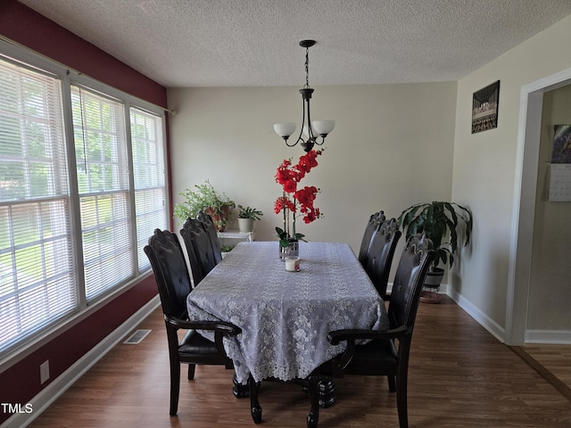 5810 Stardust Ct, Durham, NC 27712 - dining space featuring a textured ceiling, wood finished floors, baseboards, and a chandelier