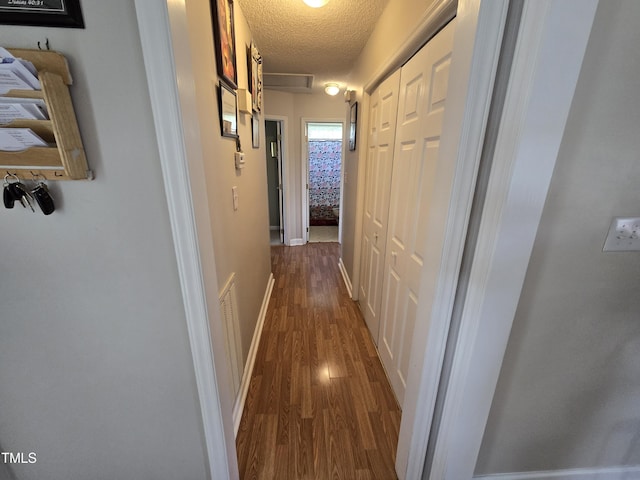 5810 Stardust Ct, Durham, NC 27712 - hall featuring dark wood finished floors and a textured ceiling