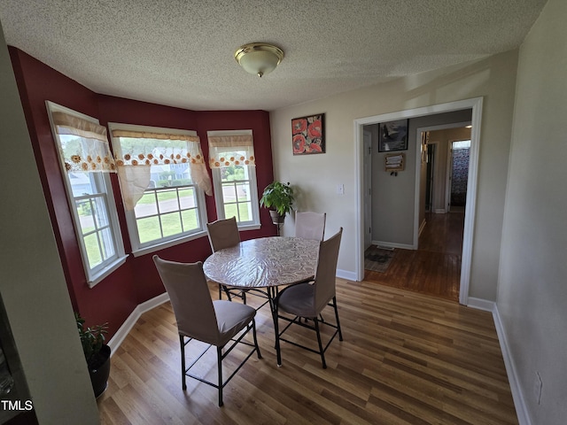 5810 Stardust Ct, Durham, NC 27712 - dining room featuring wood finished floors, baseboards, and a textured ceiling