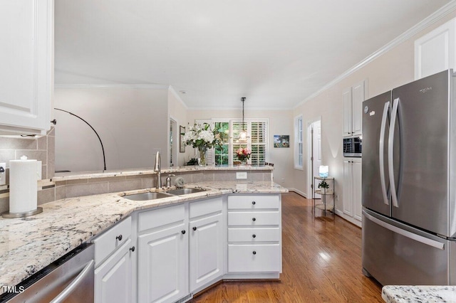 4329 Hawksong Pl, Cary, NC 27518 - kitchen featuring appliances with stainless steel finishes, a sink, a peninsula, tasteful backsplash, and white cabinetry