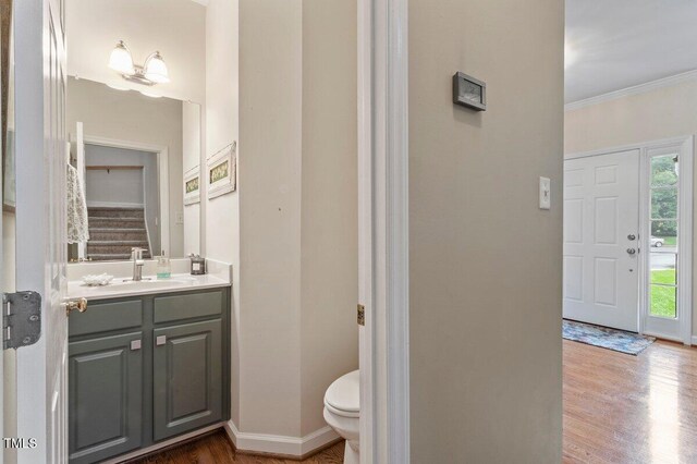 4329 Hawksong Pl, Cary, NC 27518 - half bath with vanity, toilet, wood finished floors, ornamental molding, and baseboards
