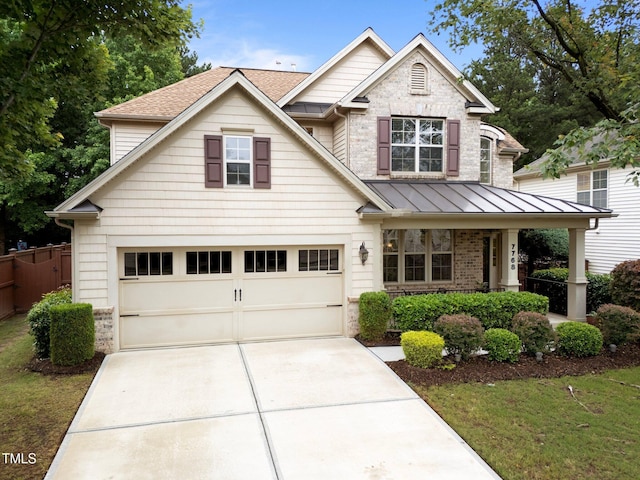 7768 Berry Crest Ave, Raleigh, NC 27617 - view of front facade featuring a garage, driveway, covered porch, a standing seam roof, and a shingled roof