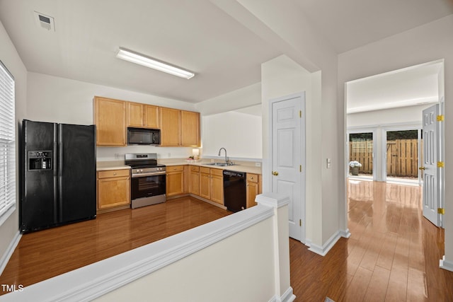 8151 Rhiannon Rd, Raleigh, NC 27613 - kitchen featuring black appliances, dark wood-type flooring, and light countertops