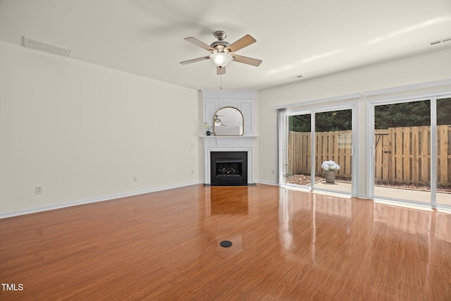 8151 Rhiannon Rd, Raleigh, NC 27613 - unfurnished living room with wood finished floors, a ceiling fan, and a fireplace