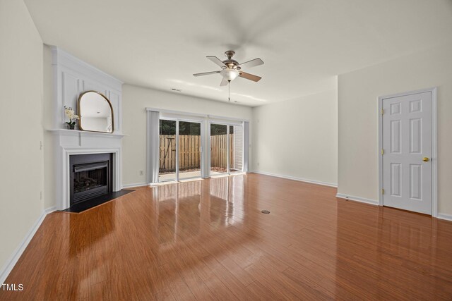 8151 Rhiannon Rd, Raleigh, NC 27613 - unfurnished living room with a ceiling fan, a fireplace with flush hearth, and wood finished floors
