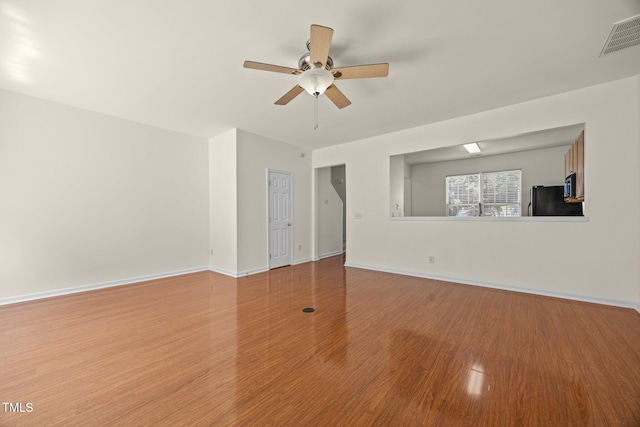 8151 Rhiannon Rd, Raleigh, NC 27613 - unfurnished living room featuring wood finished floors and a ceiling fan