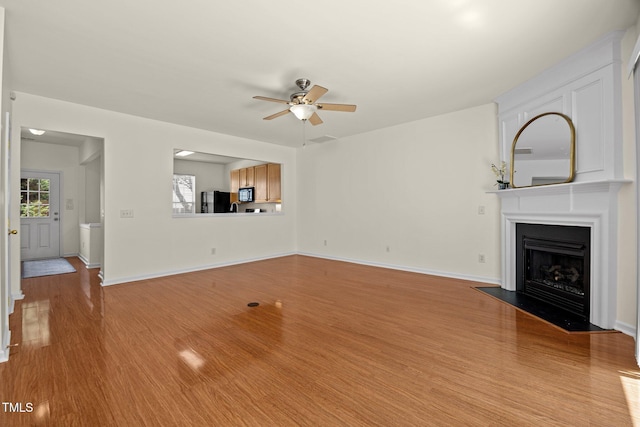 8151 Rhiannon Rd, Raleigh, NC 27613 - unfurnished living room with a ceiling fan, wood finished floors, and a fireplace with flush hearth