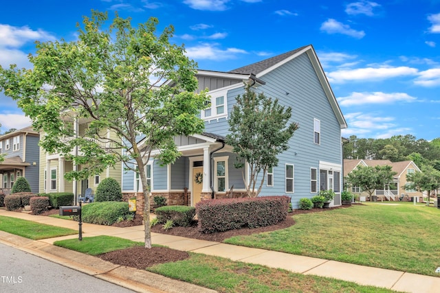 533 Duchart Ln, Fuquay Varina, NC 27526 - view of front of property featuring board and batten siding, a front lawn, stone siding, and covered porch
