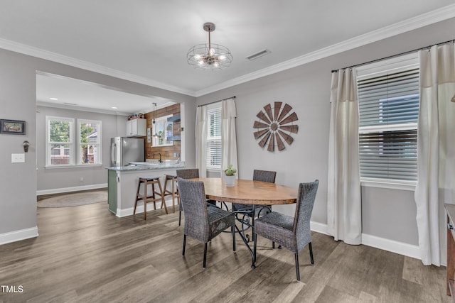 533 Duchart Ln, Fuquay Varina, NC 27526 - dining space featuring wood finished floors, a chandelier, baseboards, and ornamental molding