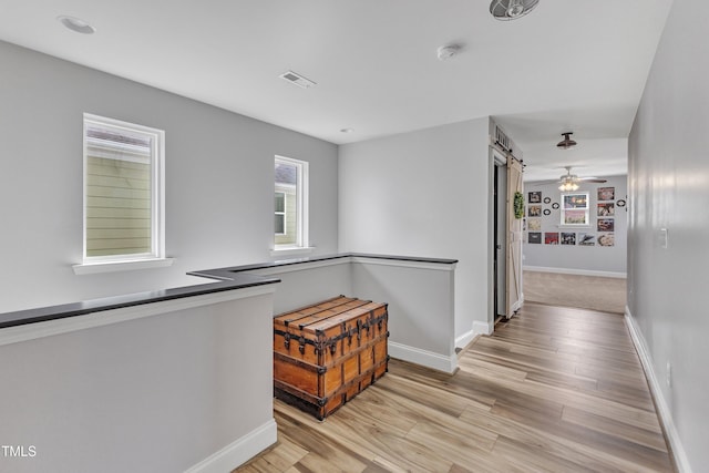 533 Duchart Ln, Fuquay Varina, NC 27526 - hallway with baseboards, light wood-style flooring, and a barn door