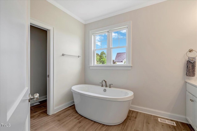 1779 Walter Grissom Rd, Kittrell, NC 27544 - bathroom with a freestanding tub, vanity, crown molding, wood finished floors, and baseboards