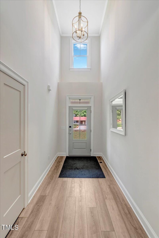 1779 Walter Grissom Rd, Kittrell, NC 27544 - entrance foyer featuring a chandelier, crown molding, a towering ceiling, wood finished floors, and baseboards