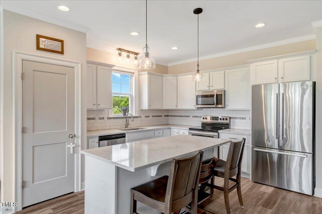 1779 Walter Grissom Rd, Kittrell, NC 27544 - kitchen with appliances with stainless steel finishes, a sink, a center island, backsplash, and ornamental molding