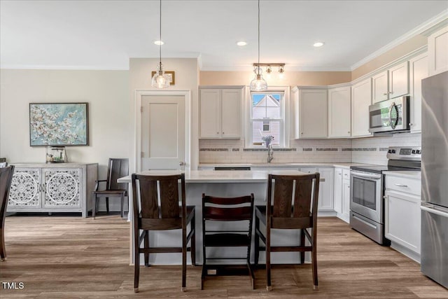 1779 Walter Grissom Rd, Kittrell, NC 27544 - kitchen with stainless steel appliances, ornamental molding, tasteful backsplash, light countertops, and a breakfast bar