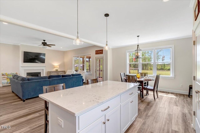 1779 Walter Grissom Rd, Kittrell, NC 27544 - kitchen featuring crown molding, light wood-type flooring, a ceiling fan, a center island, and plenty of natural light