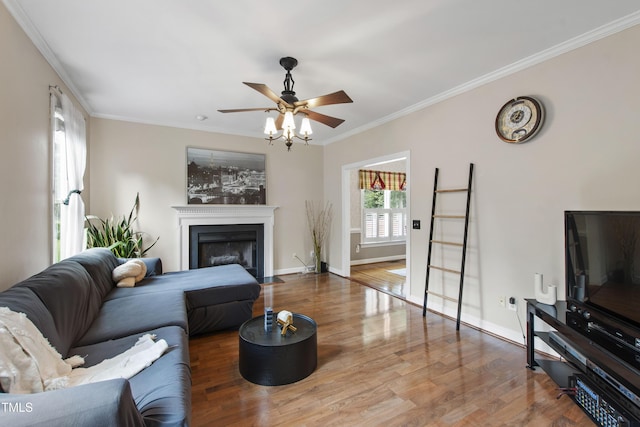102 W Hill Dr, Cary, NC 27519 - living room with wood finished floors, crown molding, a ceiling fan, a fireplace with flush hearth, and baseboards