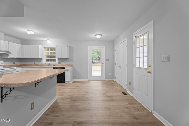 627 Gaslight Trl, Wendell, NC 27591 - kitchen featuring a sink, white electric stove, under cabinet range hood, dishwashing machine, and white cabinets