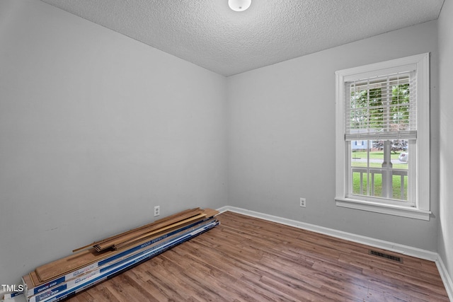 627 Gaslight Trl, Wendell, NC 27591 - empty room with wood finished floors, a textured ceiling, and baseboards