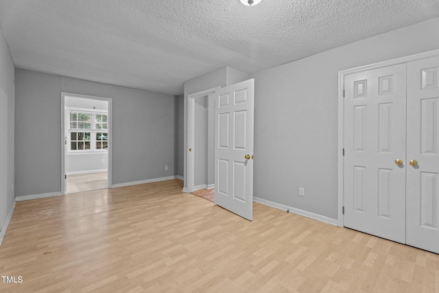 627 Gaslight Trl, Wendell, NC 27591 - unfurnished bedroom with a textured ceiling, light wood-style flooring, baseboards, and a closet