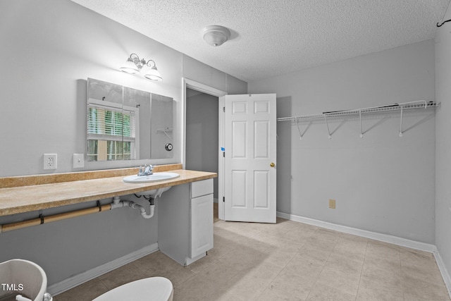 627 Gaslight Trl, Wendell, NC 27591 - bathroom with a textured ceiling, a sink, baseboards, toilet, and tile patterned flooring