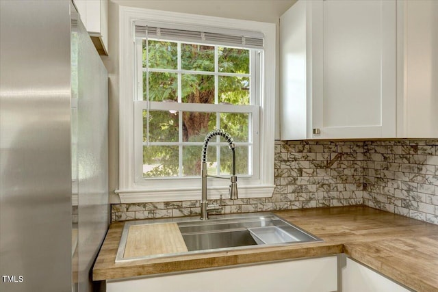 101 Apollo Cir, Roanoke Rapids, NC 27870 - kitchen with freestanding refrigerator, white cabinets, backsplash, and a sink
