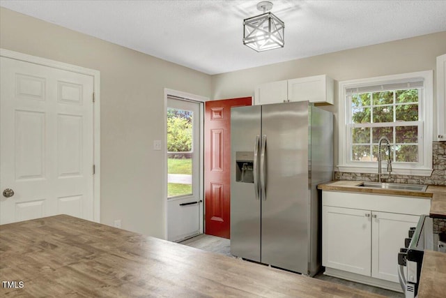 101 Apollo Cir, Roanoke Rapids, NC 27870 - kitchen with stainless steel fridge, a sink, range, white cabinetry, and light wood-style floors