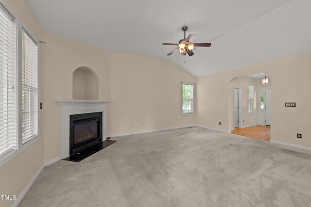 1604 Carnation Dr, Durham, NC 27703 - unfurnished living room featuring carpet floors, a fireplace with flush hearth, a ceiling fan, baseboards, and vaulted ceiling