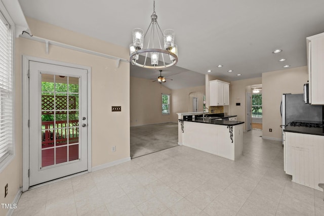 1604 Carnation Dr, Durham, NC 27703 - kitchen featuring baseboards, a chandelier, open floor plan, white cabinetry, and ceiling fan