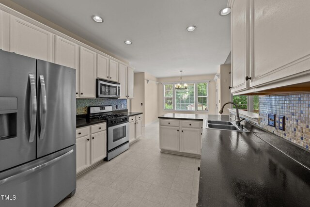 1604 Carnation Dr, Durham, NC 27703 - kitchen featuring stainless steel appliances, a sink, a chandelier, decorative backsplash, and dark countertops
