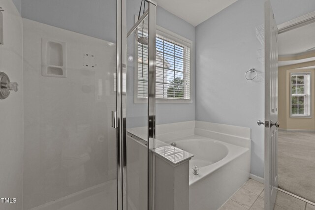 1604 Carnation Dr, Durham, NC 27703 - full bath featuring a shower stall, a bath, and tile patterned floors