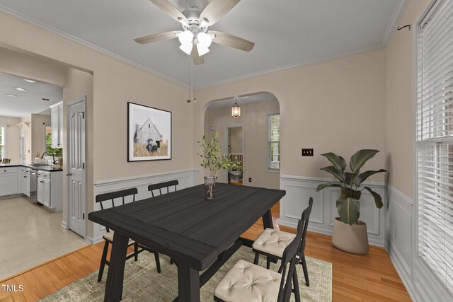 1604 Carnation Dr, Durham, NC 27703 - dining area with healthy amount of natural light, wainscoting, arched walkways, ceiling fan, and crown molding