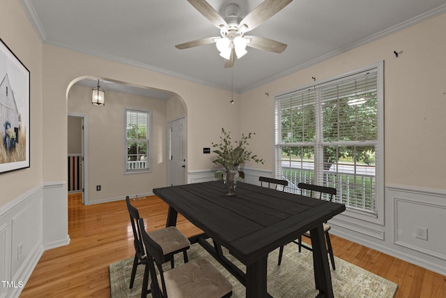 1604 Carnation Dr, Durham, NC 27703 - dining room with arched walkways, a wainscoted wall, light wood-type flooring, ceiling fan, and ornamental molding