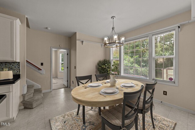 1604 Carnation Dr, Durham, NC 27703 - dining room featuring a chandelier, light tile patterned floors, stairs, and baseboards
