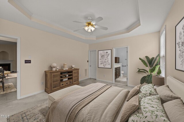1604 Carnation Dr, Durham, NC 27703 - bedroom with a raised ceiling, light carpet, ensuite bathroom, a fireplace, and baseboards
