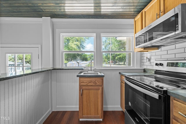 301 Williamson St, Burlington, NC 27215 - kitchen featuring appliances with stainless steel finishes, tasteful backsplash, brown cabinetry, dark wood-style floors, and ornamental molding