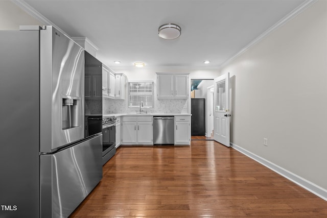 301 Williamson St, Burlington, NC 27215 - kitchen with appliances with stainless steel finishes, light countertops, dark wood-style floors, backsplash, and ornamental molding