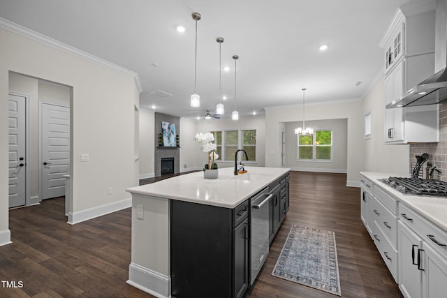 3053 Roy Ct, Apex, NC 27523 - kitchen with wall chimney exhaust hood, a chandelier, stainless steel appliances, a fireplace, and light countertops