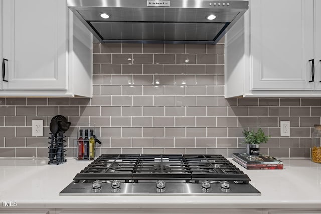 3053 Roy Ct, Apex, NC 27523 - kitchen featuring exhaust hood, stainless steel gas stovetop, white cabinetry, light countertops, and backsplash