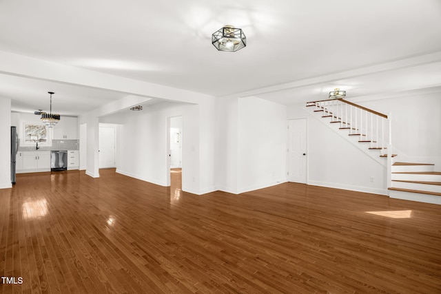 507 Price Ave, Durham, NC 27701 - unfurnished living room featuring stairs, dark wood-style flooring, baseboards, a chandelier, and a sink