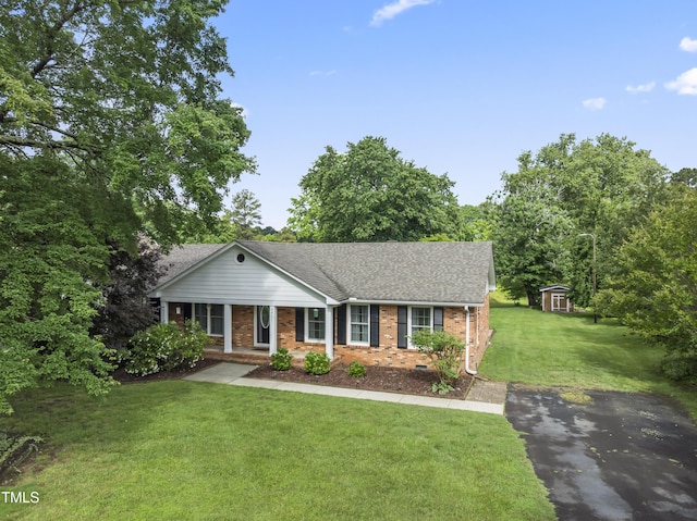 6411 Pondview Ln, Durham, NC 27712 - ranch-style home featuring brick siding, a front yard, asphalt driveway, a shingled roof, and covered porch