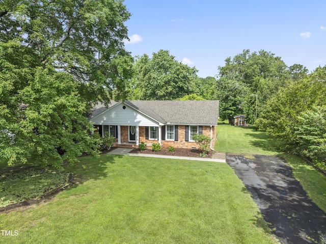 6411 Pondview Ln, Durham, NC 27712 - ranch-style home with asphalt driveway, brick siding, a front lawn, roof with shingles, and covered porch