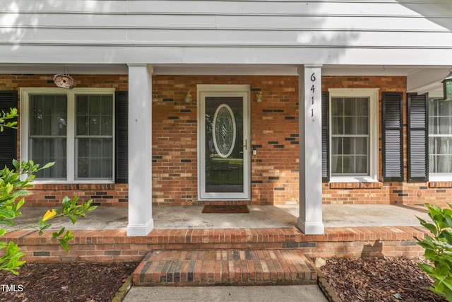 6411 Pondview Ln, Durham, NC 27712 - view of exterior entry featuring a porch and brick siding