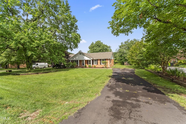 6411 Pondview Ln, Durham, NC 27712 - view of front of house featuring asphalt driveway, brick siding, and a front yard