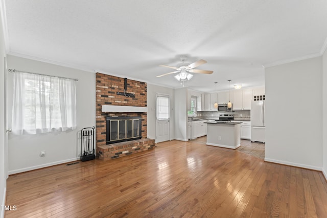 6411 Pondview Ln, Durham, NC 27712 - unfurnished living room featuring light wood-style floors, crown molding, a sink, ceiling fan, and baseboards