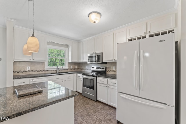 6411 Pondview Ln, Durham, NC 27712 - kitchen with appliances with stainless steel finishes, a sink, white cabinets, decorative backsplash, and decorative light fixtures