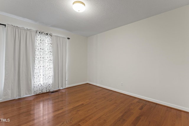 6411 Pondview Ln, Durham, NC 27712 - empty room featuring wood finished floors, baseboards, and a textured ceiling