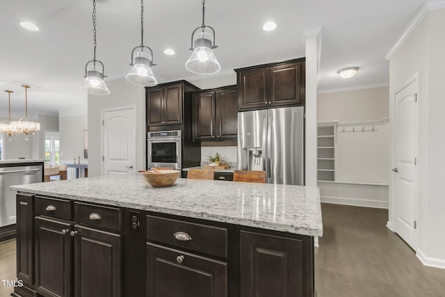 118 Manning Way, Durham, NC 27703 - kitchen with stainless steel appliances, crown molding, dark wood-style flooring, light stone countertops, and decorative light fixtures