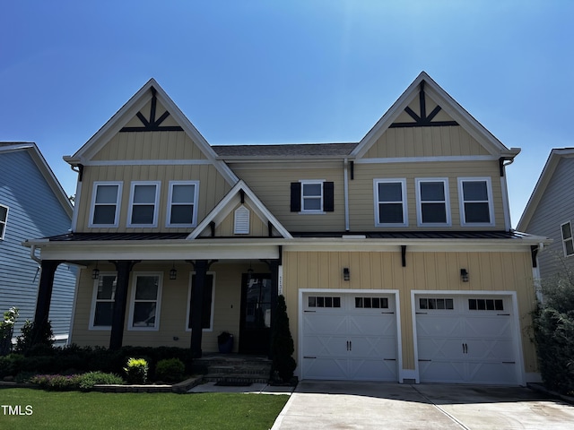 1131 Lowland St, Apex, NC 27523 - view of front of home featuring an attached garage, board and batten siding, concrete driveway, and covered porch
