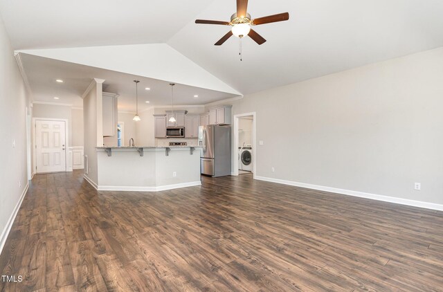 41 Tan Oak Dr, Selma, NC 27576 - unfurnished living room with washer / clothes dryer, ceiling fan, dark wood-type flooring, vaulted ceiling, and a sink