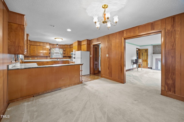4804 Spring Forest Rd, Raleigh, NC 27616 - kitchen featuring freestanding refrigerator, brown cabinetry, a chandelier, wood walls, and light colored carpet